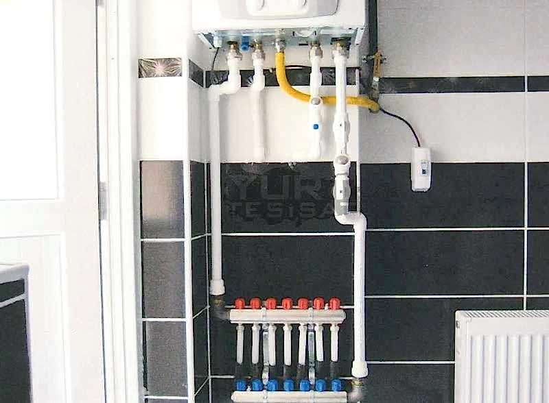 tesisatçının değiştirdiği kombinin doğalgaz ve su tesisatı bağlantıları ile radyatör peteği