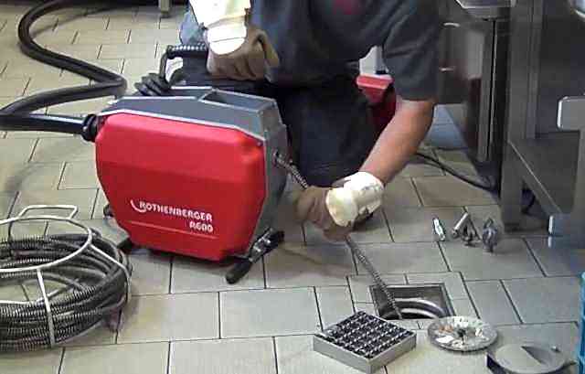 tıkanıklık açma makinesi ile çalışan tesisatçı